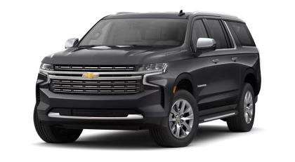 "Front side view of a 2024 Chevy Tahoe in a sleek back color, showcasing its bold grille, headlights, and streamlined design."